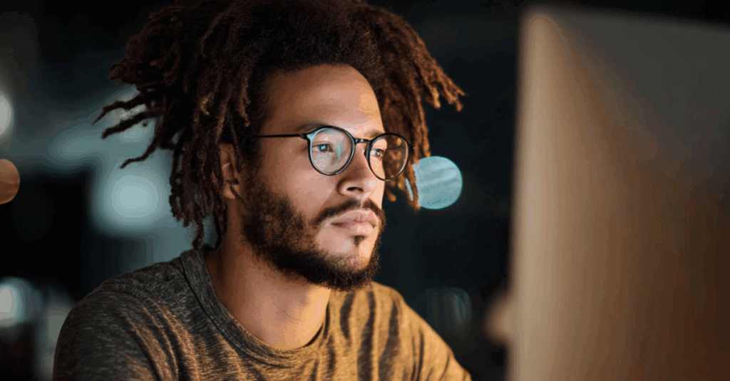 Homme concentré travaillant sur un ordinateur la nuit, symbolisant l’optimisation SEO avec les backlinks